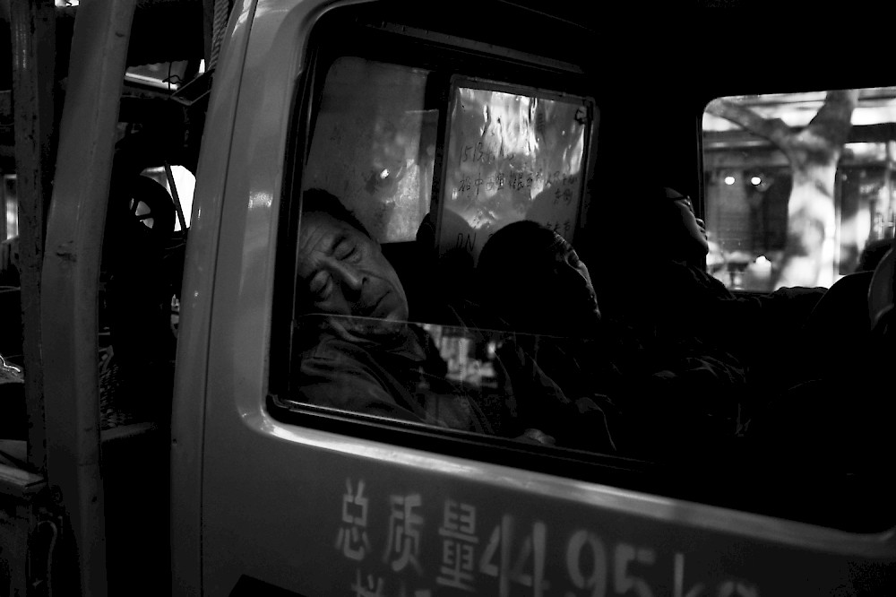 Chinese workers sleeping in a car on the streets of bejing