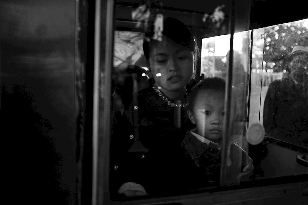 A kid is looking through the window of a taxi in bejing