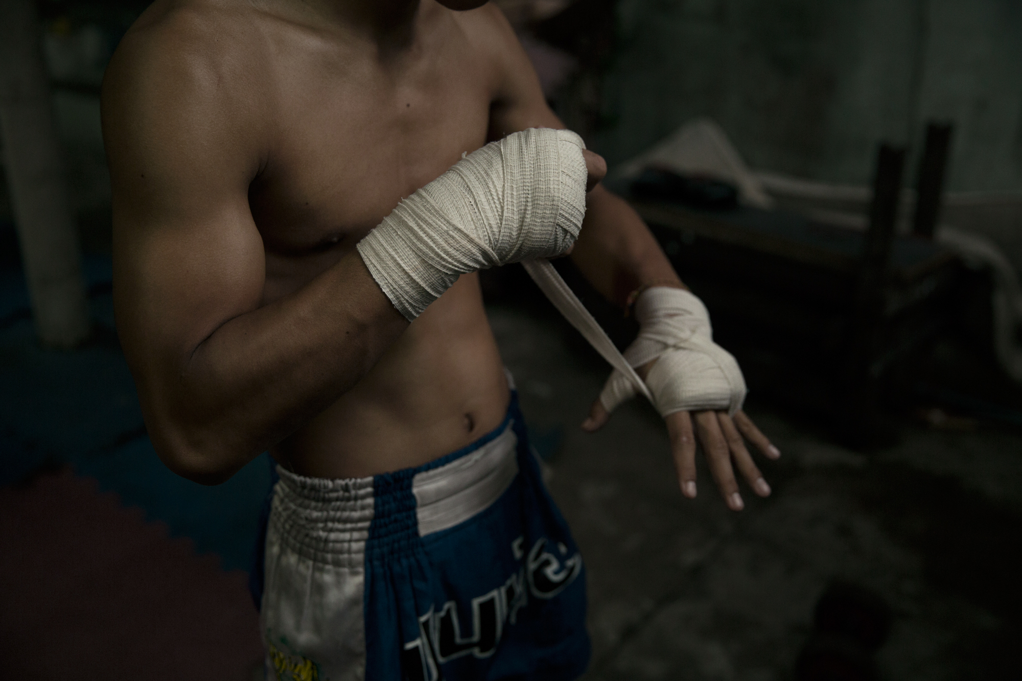 A young thai fighter photographed in Bangkok, Thailand by Maximilian Baier.
